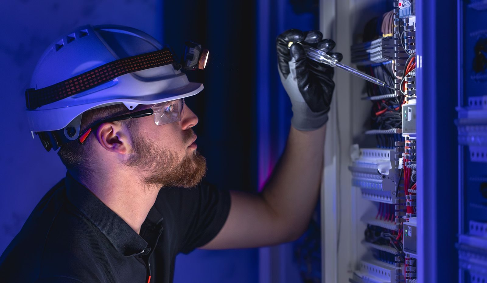 An AMS technician working inside an electrical panel